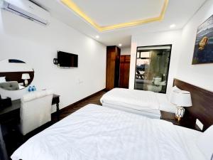 una camera d'albergo con 2 letti e una scrivania di Legacy Phú Quốc a Phu Quoc