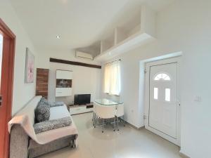 a living room with a couch and a table and a door at Apartments Ascic in Opatija