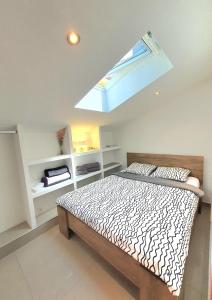 a bedroom with a bed and a skylight at Apartments Ascic in Opatija
