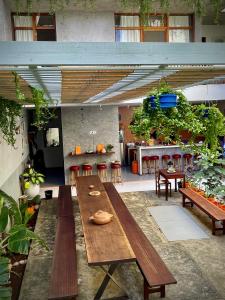 a patio with wooden tables and a kitchen with plants at Casa de Poço Guest House and Gallery in Mindelo