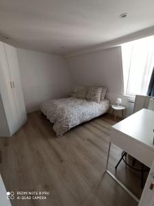 una camera da letto con un letto nell'angolo di una stanza di Appartement Dunkerque Centre a Dunkerque