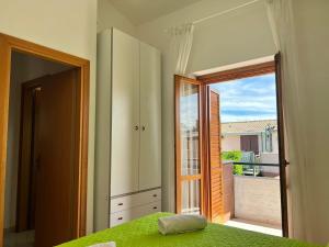 1 dormitorio con cama verde y ventana grande en New Residence, en Buonfornello