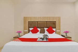 a bedroom with a large bed with red pillows at OYO Devi Residency Near Mahakali Temple in Hyderabad