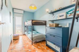 - une chambre avec des lits superposés et un mur bleu dans l'établissement Port Saplaya Waterfront Stay, à Alboraya