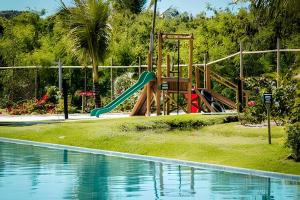 a playground with a slide next to a swimming pool at Paraiso na Praia fo Forte Village in Praia do Forte