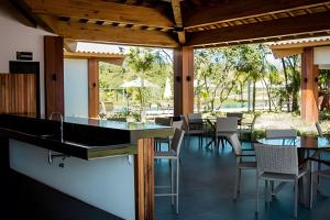 a kitchen and dining area with tables and chairs at Paraiso na Praia fo Forte Village in Praia do Forte