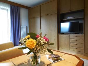 a vase of flowers on a table in a living room at Haus Kurz Matthäus in Walchsee