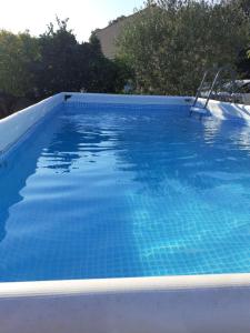 ein großer Pool mit blauem Wasser in der Unterkunft Haut de villa avec jardin (Apt T3) in Bormes-les-Mimosas