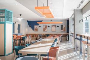 a dining room with tables and chairs at ibis budget Manchester Airport in Hale