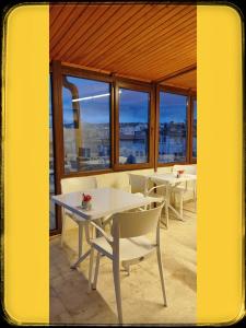 a dining room with tables and chairs and windows at Yellow Stone House in Goreme