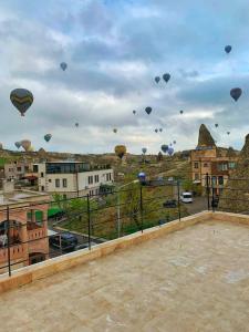a bunch of hot air balloons flying in the sky at Yellow Stone House in Goreme