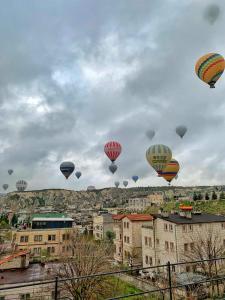 a group of hot air balloons flying over a city at Yellow Stone House in Goreme