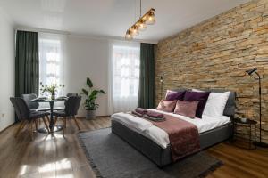 a bedroom with a brick wall and a bed and a table at Várvédőház Apartmanok Eger in Eger