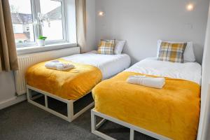 due letti singoli in una stanza con finestra di Dings House With FREE Parking In Super Central South West City Location By StayStaycations a Bristol