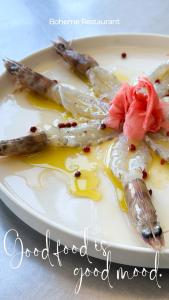 um prato branco de comida com marisco em La Bohème Hotel em Tirana