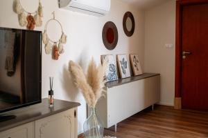 a living room with a vase with feathers on the wall at Stone House With Jacuzzi "DINARA" in Kijevo