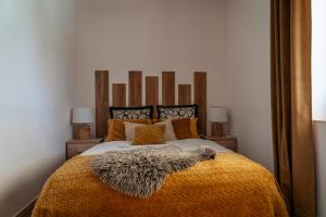 a bedroom with a large bed with an orange blanket at Stone House With Jacuzzi "DINARA" in Kijevo
