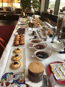 uma longa mesa cheia de diferentes tipos de pastelarias em La Bohème Hotel em Tirana