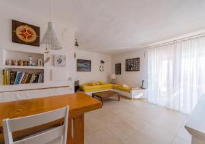 a living room with a table and a yellow couch at PGS IMMOBILIARE SRLS – Pagello D – Trilocale vista mare– La Maddalena in Casale Azara