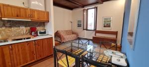 cocina y sala de estar con mesa de cristal en Bilocale - Lago di Como apt, en Menaggio