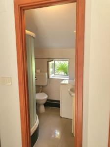 a bathroom with a toilet and a window at Apartments Ascic in Opatija