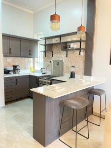 a kitchen with a large island with bar stools at Athena Apartments in Kampala