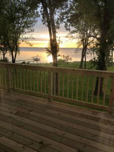 a wooden fence on a deck with a view of the water at Goyke -Gorgeous Lakefront in Van Dyne