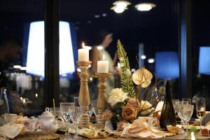uma mesa com velas e flores sobre uma mesa em La Bohème Hotel em Tirana