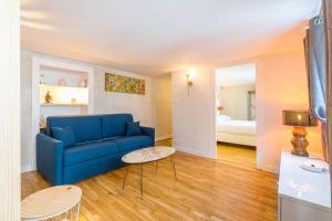 a living room with a blue couch and a bed at Le Duplex des Ducs in Dijon +7 photos