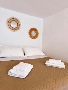 a bedroom with two towels on a bed with two mirrors at Moma Apartment in Kithnos