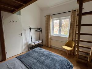 a bedroom with a bed and a chair and a window at 3 Bedroom Town House in Central Muswell Hill London in London