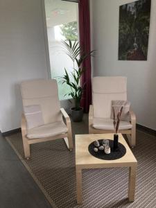 2 sedie e un tavolino in soggiorno di Gemütliche 2 12 - Parterre-Ferienwohnung mit Terrasse - b48858 