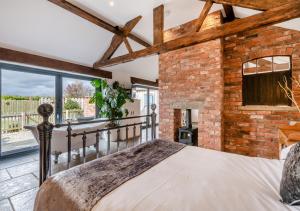 a bedroom with a bed and a brick wall at Sunset Barn in Normanby