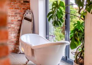 a white bath tub in a bathroom with a plant at Sunset Barn in Normanby