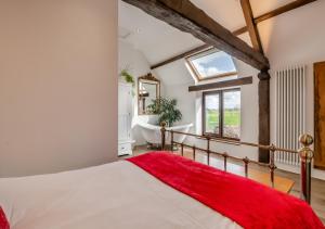 1 dormitorio con 1 cama grande, ventana y bañera en The Roost en Normanby