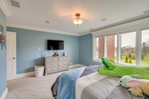 ein Schlafzimmer mit einem grünen ausgestopften Tier, das auf einem Bett liegt in der Unterkunft Spacious Inverness Home about 36 Mi to Chicago! in Barrington Hills