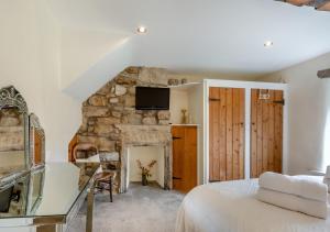 1 dormitorio con chimenea de piedra y 1 cama en Newby Cottage en Newby