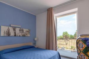 a bedroom with a bed and a large window at Hotel Villa d'Amato in Palermo