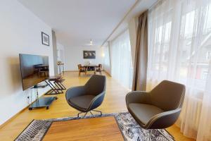 a living room with two chairs and a flat screen tv at Amazing/sunny 2 bedroom flat in the city center (West 6) in Zurich