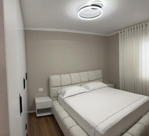 a white bed in a bedroom with a white ceiling at Luxury Center Apartments in Tirana
