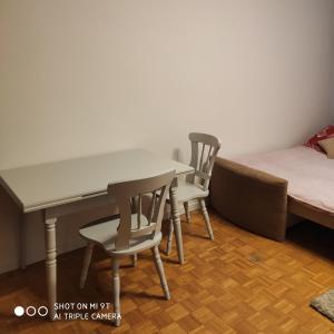 ein Zimmer mit einem Tisch, 2 Stühlen und einem Sofa in der Unterkunft Korona Apartament in Warschau