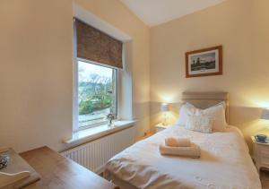 a bedroom with a white bed with a window at Viaduct View in Ingleton