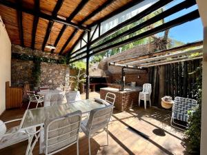 Un patio con mesa y sillas y un edificio. en Casa guerrero, con piscina en chacras, en Ciudad Lujan de Cuyo
