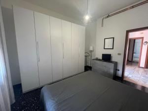 a bedroom with white cabinets and a bed in it at Appartamento Chiesina Uzzanese - Toscana in Chiesina Uzzanese