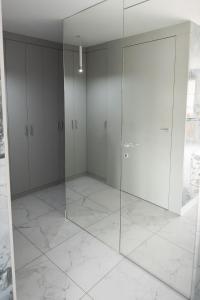 a room with white cabinets and a glass door at Apartament Jacuzzi in Gdynia