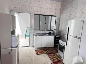 a kitchen with a refrigerator and a sink in it at Casa bem localizado em Sinop in Sinop