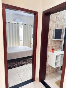 - une chambre avec un lit et un miroir dans l'établissement Casa bem localizado em Sinop, à Sinop