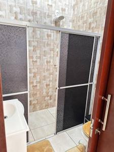 ein Bad mit einer Dusche und einem Waschbecken in der Unterkunft Casa bem localizado em Sinop in Sinop