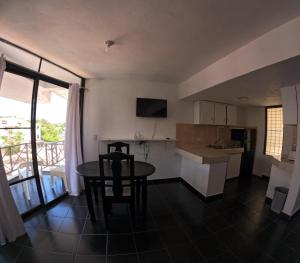 a kitchen and dining room with a table and a table and chairs at Hotel El Legendario in Sosúa
