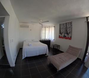 a bedroom with a bed and a couch in it at Hotel El Legendario in Sosúa